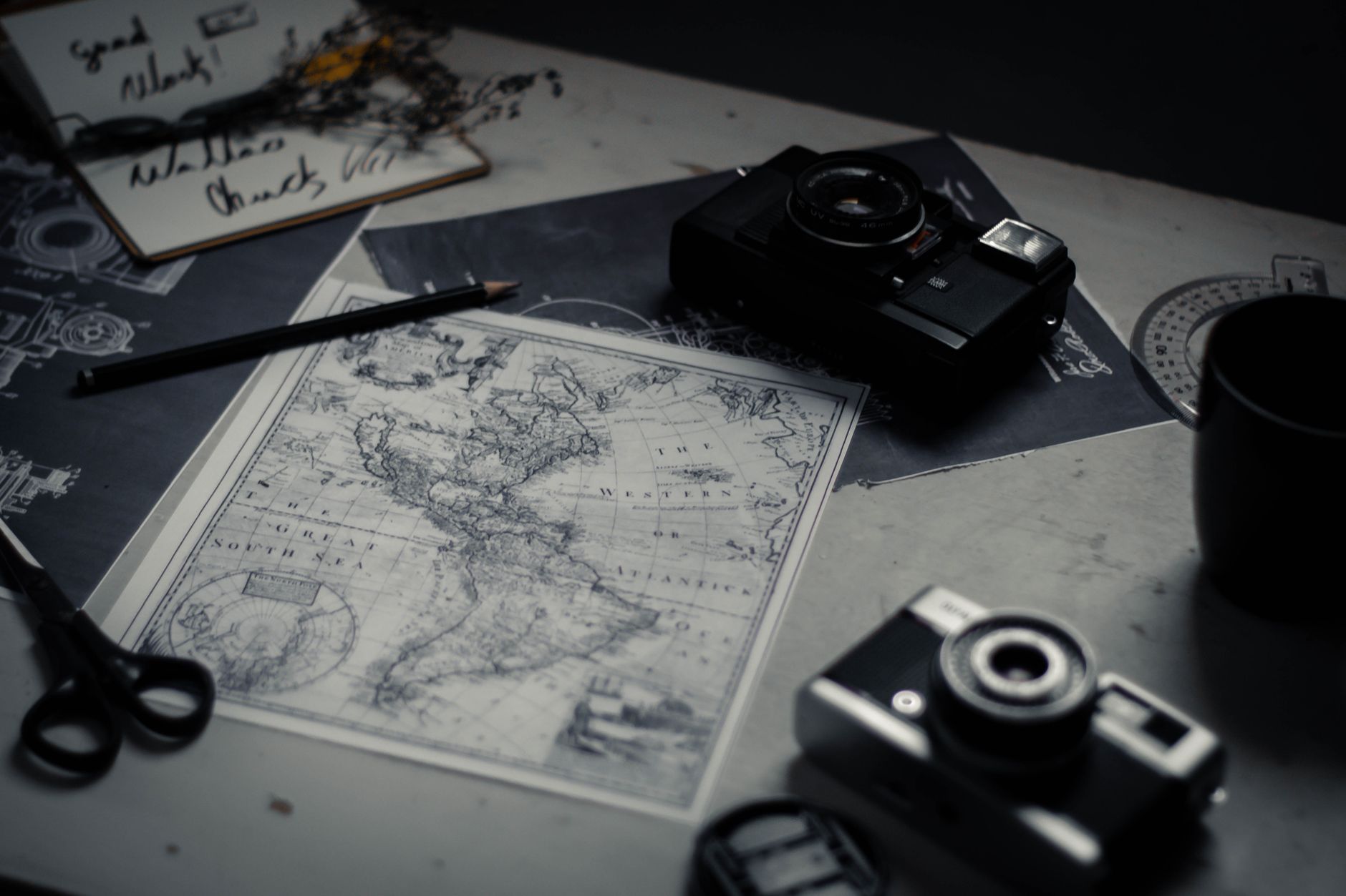 Quiet travel planning studio with maps and cameras